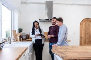 Relocation services agent meeting with two men in apartment to discuss Dublin real estate